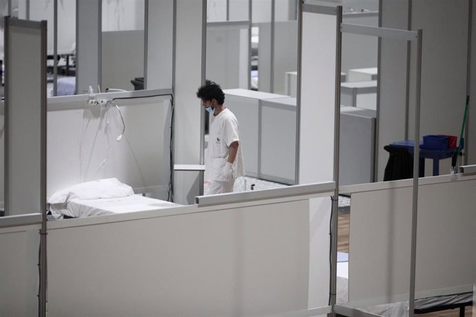 Archivo - Un profesional sanitario frente a una cama vacía en el interior del hospital de campaña de IFEMA durante su último día de funcionamiento por la bajada de la presión asistencial. 