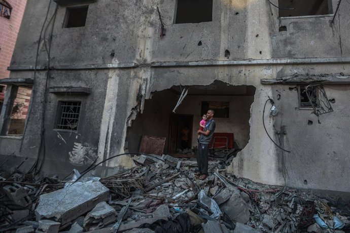 Archivo - Un palestino frente a un edificio destruido en un ataque de Israel contra la Franja de Gaza