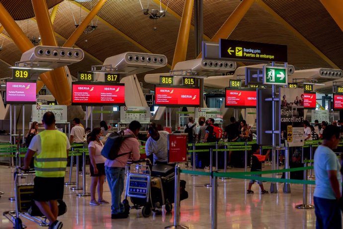 Varios pasajeros esperan para obtener sus tarjetas de embarque y facturar su equipaje en la T4 del Aeropuerto Adolfo Suárez Madrid-Barajas, a 28 de agosto de 2022, en Madrid (España). 