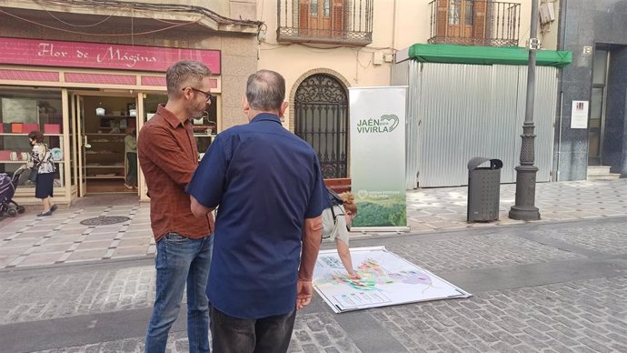 Ureña (i) observa el mapa instalado en la calle Bernabé Soriano.