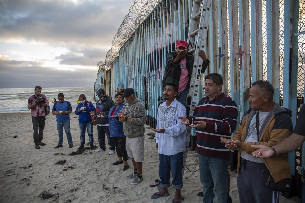 Archivo - Una docena de migrantes de diferentes nacionalidades se acercaron al muro de la playa de Tijuana, en la frontera con Estados Unidos, para conmemorar las muertes y pedir una reforma migratoria en ese país. 