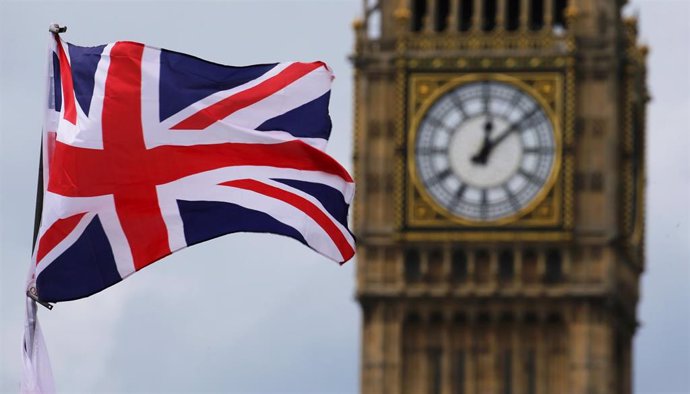 Archivo - FILED - 24 June 2016, United Kingdom, London: The British Union Jack, flies in front of the Big Ben, the clock face of the Elizabeth Tower. The refurbishment of London's Big Ben tower and clock will be finished next year, the British parliamen