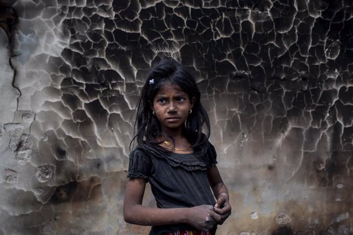 Archivo - Una niña refugiada rohingya frente a un muro quemado tras el gran incendio que se produjo  en el campo de refugiados de Balukhali, en Cox's Bazar