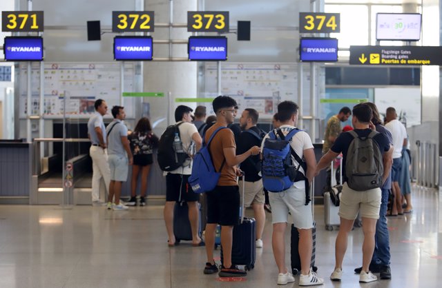 Archivo - Cientos de turistas hacen colas en los puestos de embarque de Ryanair, en el Aeropuerto Costa del Sol, en Málaga, Andalucía.