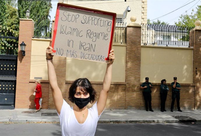 Una mujer con un cartel para protestar contra el régimen de Irán durante una concentración frente a la Embajada en Madrid