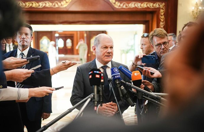 25 September 2022, Qatar, Doha: German Chancellor Olaf Scholz (C) speaks to media at Doha airport. Photo: Kay Nietfeld/dpa