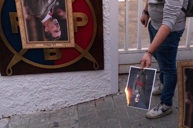 Archivo - Un manifestante quema un retrato del Rey en una protesta en Barcelona 