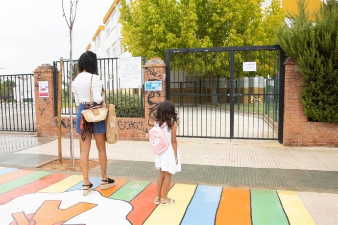 Una madre con su hija en las inmediaciones de un centro educativo.