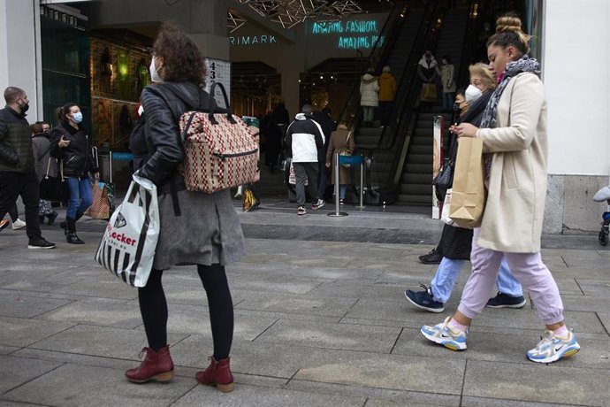 Archivo - Varias personas con bolsas pasean. Imagen de archivo.