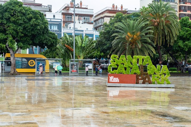 Varias personas se refugian de la lluvia bajo los paraguas en el parque Santa Catalina, a 25 de septiembre de 2022, en Las Palmas de Gran Canaria, Canarias (España). 