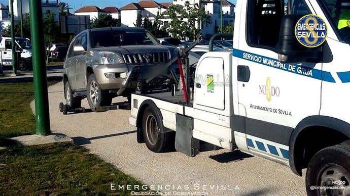 Archivo - Imagen de archivo de un coche retirado por la grúa municipal en Sevilla.