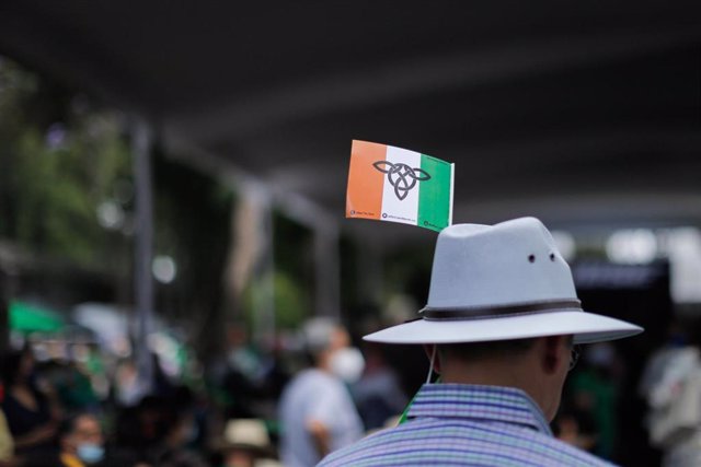 Un hombre con una bandera irlandesa en su sombrero