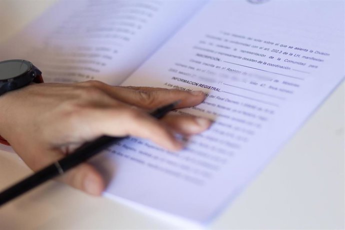 Archivo - Una mujer con un bolígrafo señala una escritura registral.