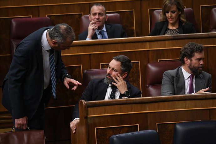 (I-D) El secretario general de Vox, Javier Ortega Smith; el presidente de Vox, Santiago Abascal, y el portavoz del Grupo Parlamentario Vox, Iván Espinosa de los Monteros, conversan en una sesión plenaria en el Congreso de los Diputados.