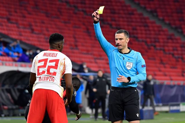 Archivo - 16 February 2021, Hungary, Budapest: Leipzig's Nordi Mukiele (L)is shown a yellow card by referee Slavko Vincic during the UEFAChampions League round of 16 first leg soccer match between RB Leipzig and FC Liverpool at Puskas Arena. Photo: Ma