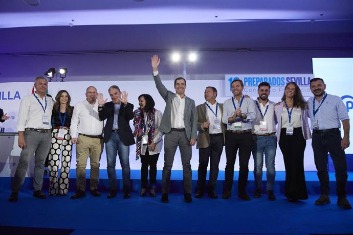 El presidente de la Junta de Andalucía, Juanma Moreno, (c) preside la foto de familia junto al presidente provincial del PP de Sevilla, Ricardo Sánchez, (5d) y varios miembros destacados del partido en el ámbito nacional y regional.