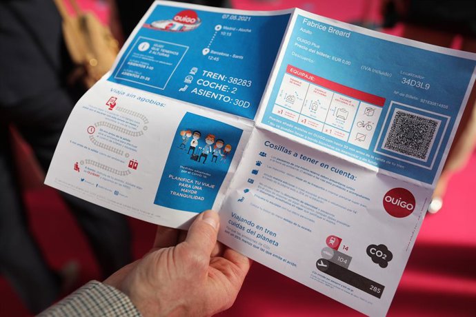 Archivo - Una persona muestra un flleto explicativo durante la inauguración del primer trayecto de Ouigo