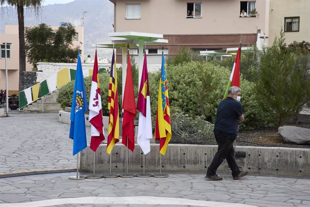Archivo - Un operario retira las banderas de las comunidades autónomas, en la entrada del Museo Arqueológico Benahoarita, a 13 de marzo de 2022, en Los Llanos de Aridane, La Palma, Canarias (España)