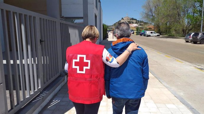 Una voluntaria de Cruz Roja acompañando a una persona mayor.