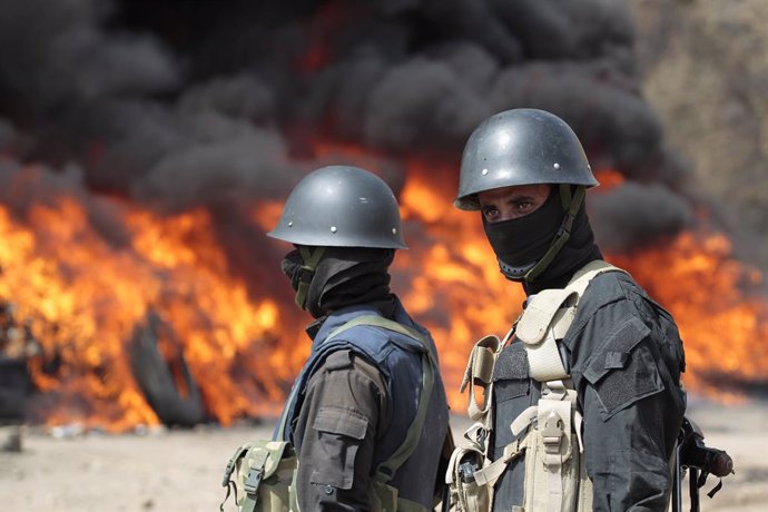 Archivo - 26 June 2022, Yemen, Sanaa: Yemeni soldiers stand guard as flames and smoke rise from a burning pile of seized narcotics during a destruction ceremony organized to mark the International Day Against Drug Abuse and Illicit Trafficking. Houthi-r