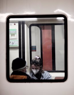 Archivo - Dos pasajeros dentro de un tren en la estación de Sol 