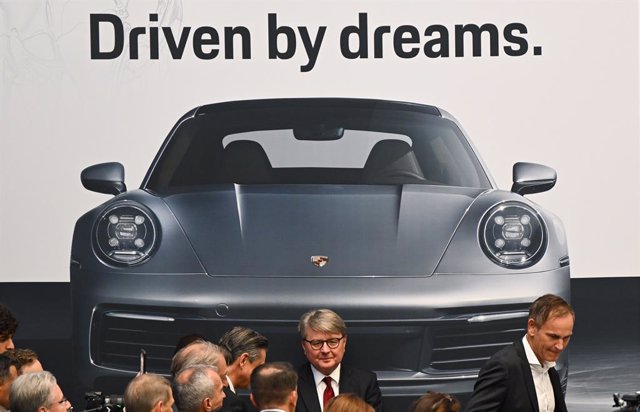 FILED - 29 September 2022, Hessen, Frankfurt_Main: Oliver Blume (R), Chairman of the Board of Management of Volkswagen AG and Porsche AG, and Theodor Weimer (C), Chairman of the Board of Management of Deutsche Boerse AG, stand in front of a poster reading