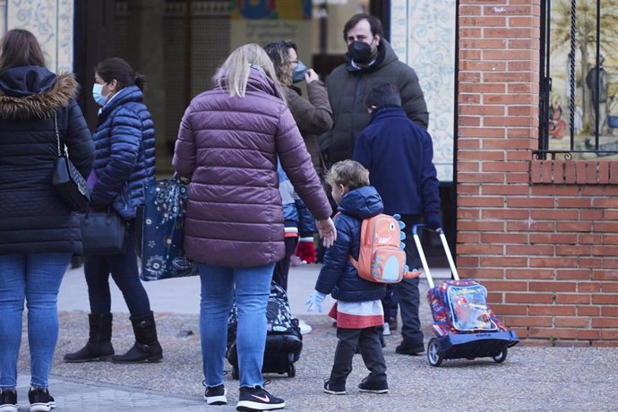 Archivo - Una madre deja a su hijo en la puerta del colegio.