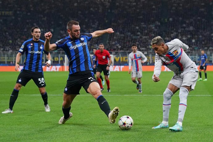 04 October 2022, Italy, Milan: Barcelona's Raphinha (R) and Inter Milan's Stefan de Vrij battle for the ball during the UEFA Champions League Group C soccer match between Inter Milan and FC Barcellona at San Siro Stadium. Photo: Spada/LaPresse via ZUMA 