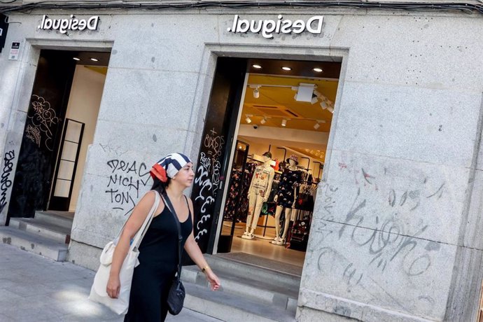 Archivo - Una persona pasa por delante de un escaparate de una tienda de ropa, a 2 de septiembre de 2022, en Madrid (España). 