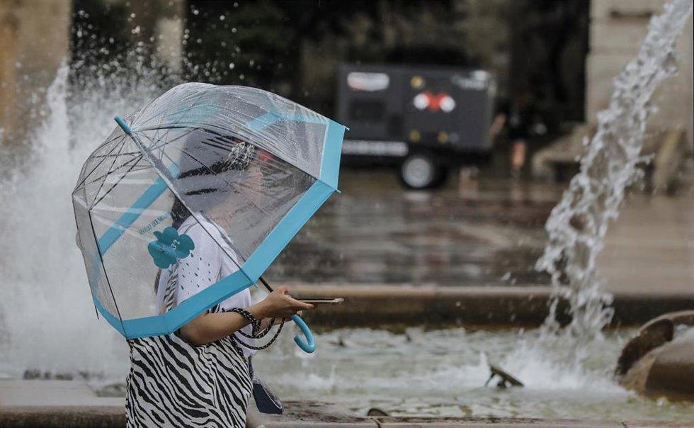 Archivo - Una persona sostiene un paraguas mientras llueve, a 26 de julio de 2021, en Valencia, Comunidad Valenciana, (España). Para esta jornada, con nivel máximo naranja, se espera cielo nuboso que tenderá a intervalos nubosos al final y viento de com