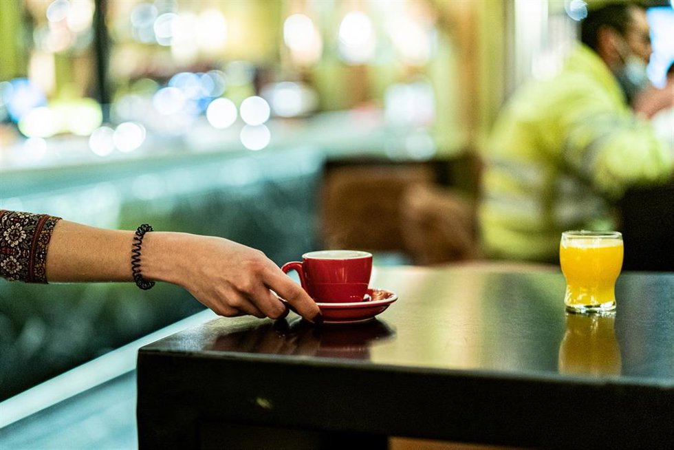 Archivo - Una trabajadora lleva un café.