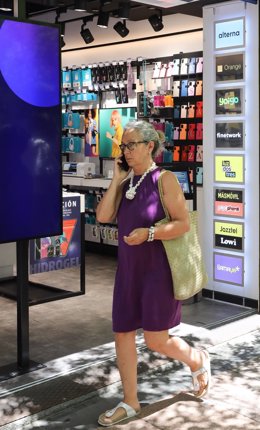 Archivo - Una mujer pasa por una tienda Phone House, a 26 de julio de 2022, en Madrid (España). 