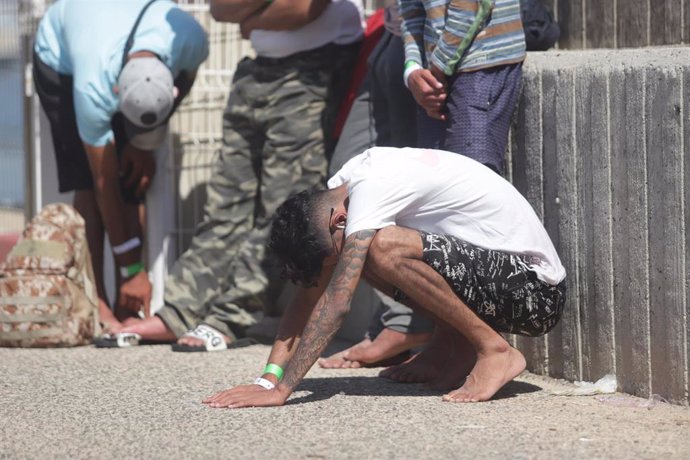 Un inmigrante rescatado se apoya en el suelo durante el rescate de 31 magrebíes, diez menores, de una patera en aguas de Barbate, a 23 de septiembre de 2022 en Cádiz (Andalucía, España). Efectivos de Salvamento Marítimo han rescatado este viernes a 31 i