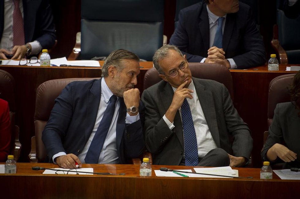 El vicepresidente, consejero de Educación y Universidades de la Comunidad de Madrid, Enrique Ossorio, conversa con el consejero de Presidencia, Justicia e Interior, Enrique López, durante una sesión plenaria en la Asamblea de Madrid, a 6 de octubre de 2