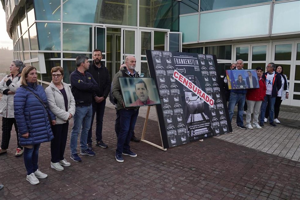 Familiares de las víctimas del accidente con un cartel del documental 'Frankenstein', en las inmediaciones de la Cidade de la Cultura, durante la primera jornada del juicio por el accidente ferroviario de Alvia, a 5 de octubre de 2022, en Santiago de Co