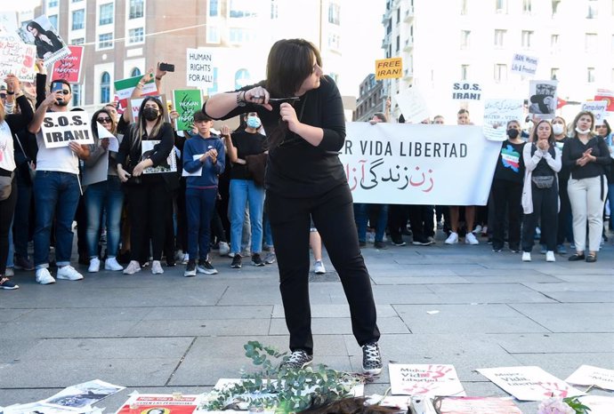 Una chica se corta el pelo, como forma de protesta, para pedir respeto por los derechos de las mujeres iraníes, en la plaza del Callao,en Madrid