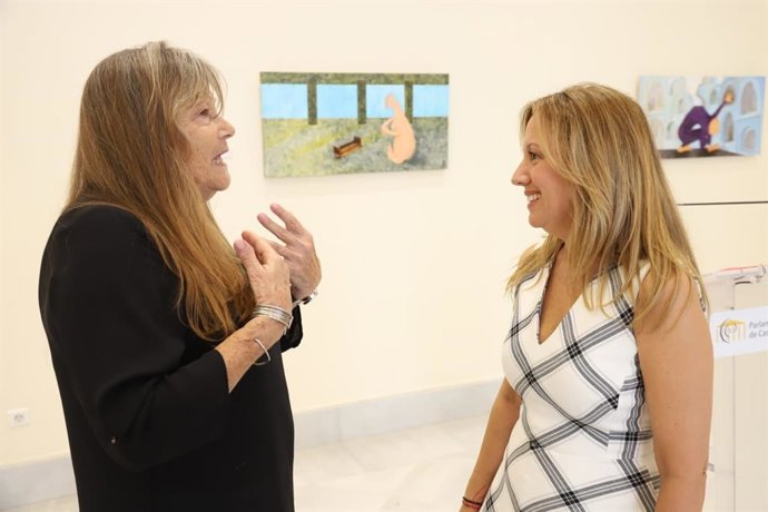 La vicepresidenta del Parlamento, Rosa Dávila (d), conversa con una de las autoras de la muestra 'Dos miradas'