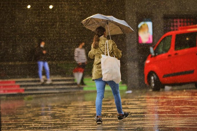 Archivo - Una persona camina por el centro de la capital en una jornada marcada por las lluvias y la bajada de temperaturas, en Madrid, (España), a 2 de octubre de 2020. Esto se debe a la llegada de la borrasca atlántica Alex que se profundiza desde aye