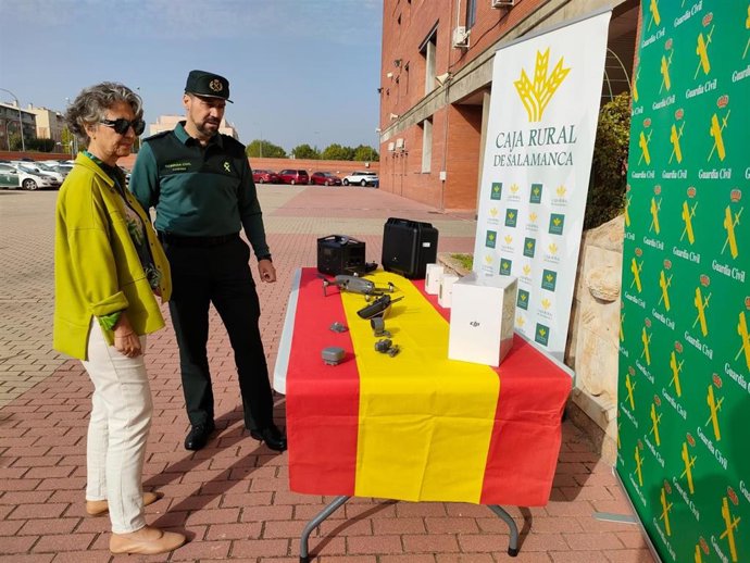 El teniente coronel jefe de la Comandancia de la Guardia Civil de Salamanca, Pedro Merino Castro, y la directora general de Caja Rural de Salamanca, Isabel Martín Arija, observan el nuevo dron donado por la entidad financiera al Instituto.