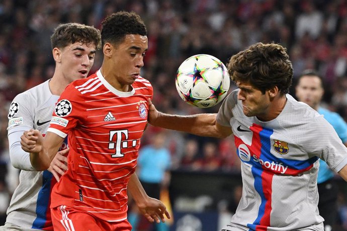 13 September 2022, Bavaria, Munich: Munich's Jamal Musiala (C) battles for the ball with Barcelona's Gavi (L) and Marcos Alonso during the UEFAChampions League Group C soccer match between FC Bayern Munich and FC Barcelona at Allianz Arena. Photo: Pete