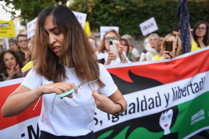 Una mujer se corta el pelo en una concentración frente a la Embajada de Irán en Madrid