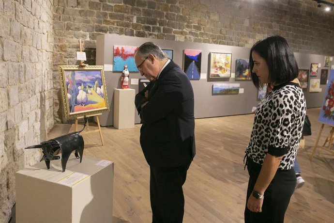 El alcalde de Pamplona, Enrique Maya, contempla la obra que ha adquirido el Ayuntamiento de Pamplona de un escultor ucraniano en una exposición benéfica.