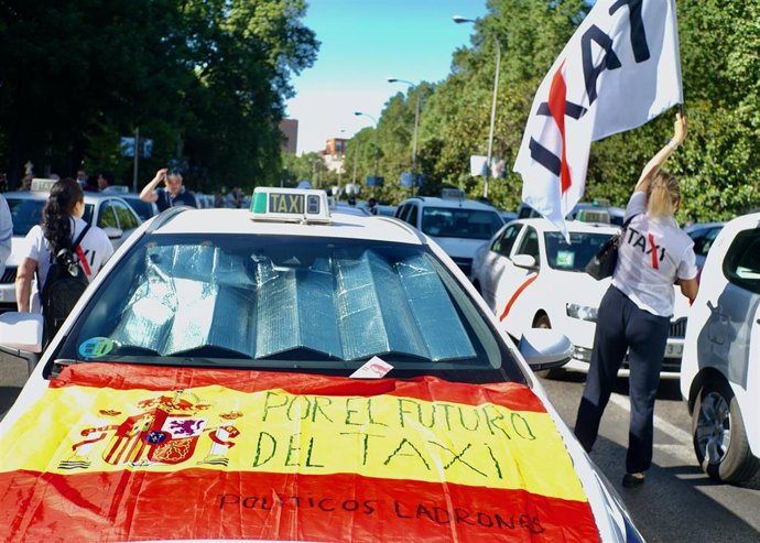 Archivo - Un taxi con una bandera de España en la que se lee: 'Por el futuro del taxi'.
