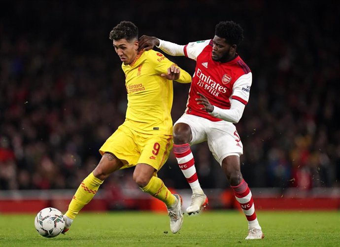 Archivo - 20 January 2022, United Kingdom, London: Liverpool's Roberto Firmino (L) and Arsenal's Thomas Partey battle for the ball during the English Carabao Cup semi final second leg soccer match between Arsenal and Liverpool at the Emirates Stadium. P