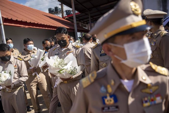 Oficilaes tailandeses con ramos de flores en la guardería tiroteada