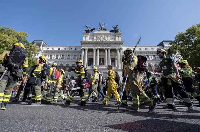 Varios bomberos y bomberas marchan, delante del Ministerio de Agricultura