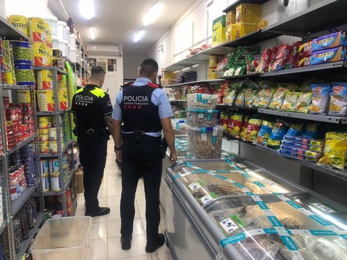 Els Mossos d'Esquadra, la Gurdia Urbana de Barcelona i inspectors de sanitat inspeccionen un local comercial a Barcelona
