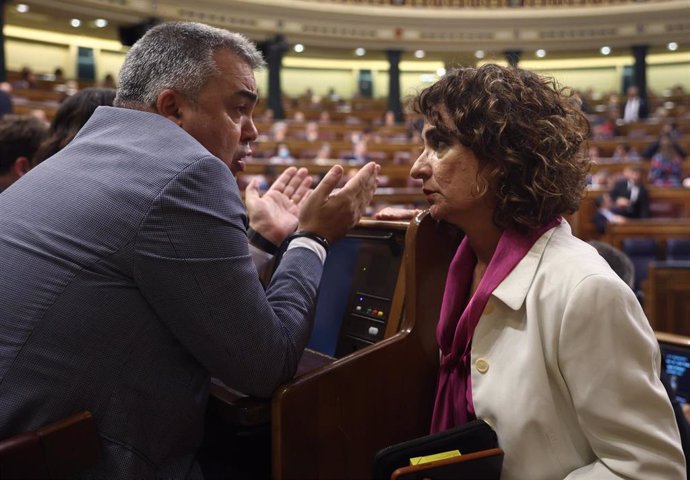 El secretario de Organización del Partido Socialista, Santos Cerdán y la ministra de Hacienda, María Jesús Montero, conversan durante una sesión plenaria, en el Congreso 