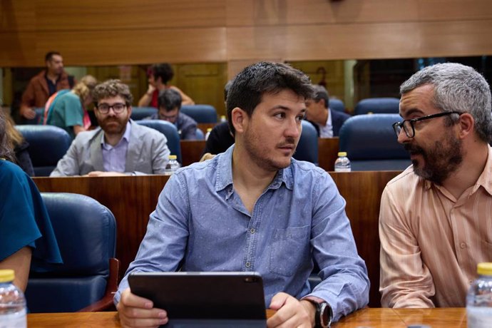 El diputado y senador de Más Madrid, Pablo Gómez Perpiny (c), conversa con el diputado de Más Madrid, Javier Padilla Bernáldez (d) durante la segunda jornada del debate del Estado de la Región, en la Asamblea de Madrid, a 13 de septiembre de 2022, en M
