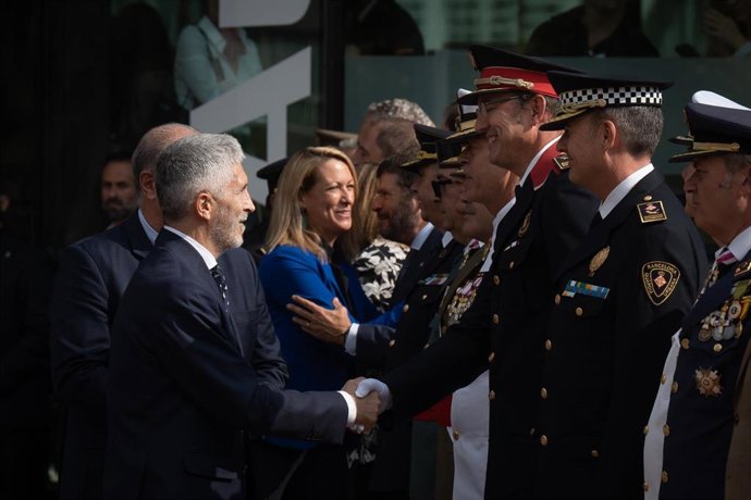 El ministro de Interior, Fernando Grande-Marlaska (i), saluda al comisario jefe de los Mossos d'Esquadra, Josep Maria Estela (d), a su llegada a un acto por el Día de la Policía Nacional, a 10 de octubre de 2022, en Barcelona, Cataluña (España). 